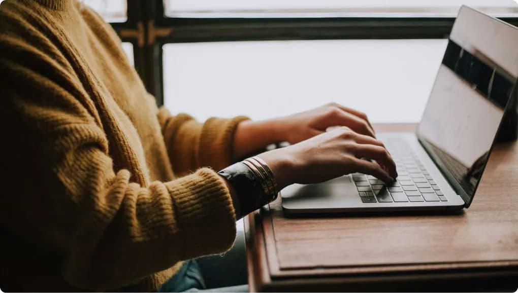 A person typing on a laptop keyboard. 